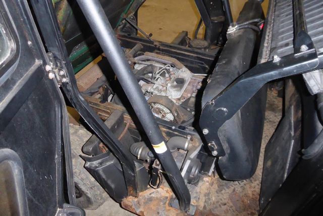 Kawasaki KAF950G truck equipment interior with engine components visible, belts, pulleys, and metal framework.