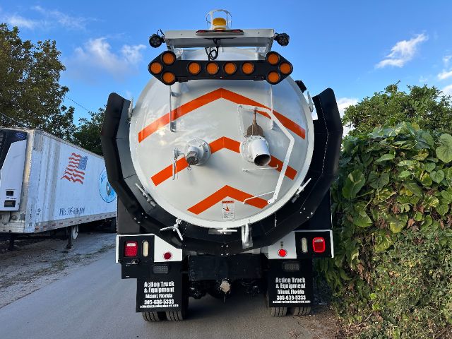 Rear view of a 2016 International 7400 vacuum truck tank with orange reflective chevrons, taillights, and hoses.