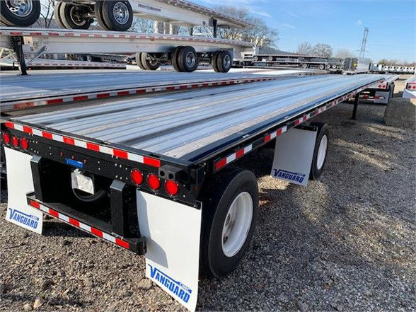 Vanguard 48ft steel flatbed trailer showing flatbed deck, dual rear axles, and white Vanguard mud flaps.
