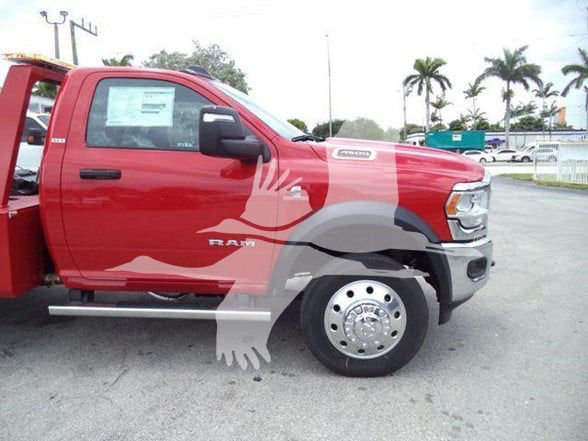 Ram 4500 truck side view showing front fender badge and large chrome wheel, red cab with graphics.