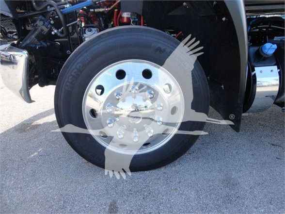 Wheel and tire assembly on a 2023 International MV truck showing polished steel rim and tubeless tire with visible lug nuts.
