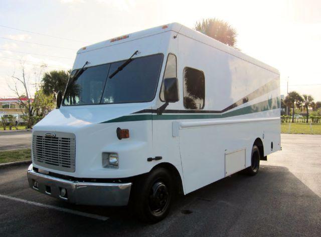 Workhorse P42 step van in white with green stripe, front view angled, daytime.