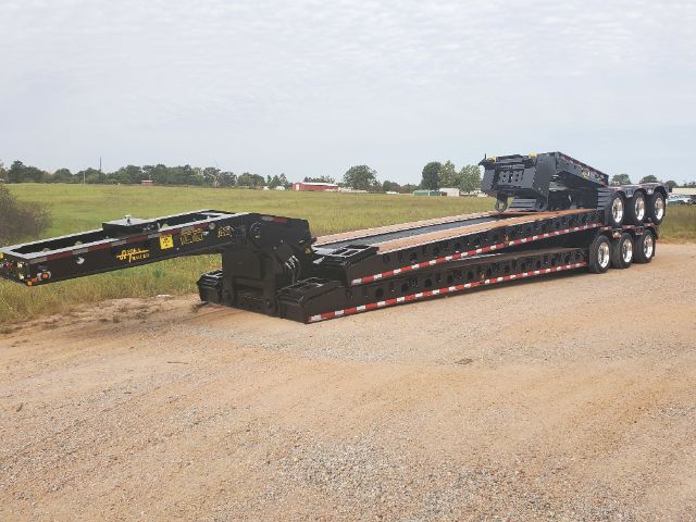 Trailer showing lowboy deck and multiple axles with Atoka branding and model tag, in an open lot.