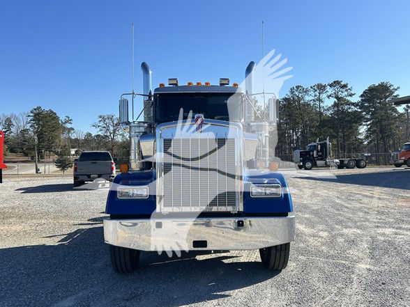 Kenworth W900L conventional daycab truck front view with blue paint and chrome bumper.