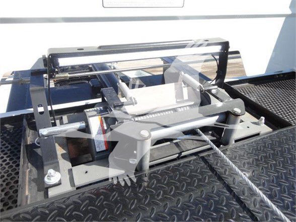 Equipment hitch or tow accessory mounted on a truck bed with metal framework and hydraulic components.