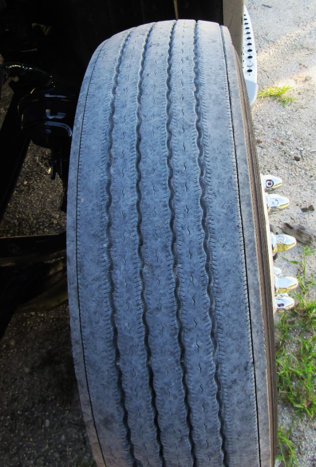 Tire view on Kenworth T680 chassis showing worn tread pattern and sidewall near wheel well.