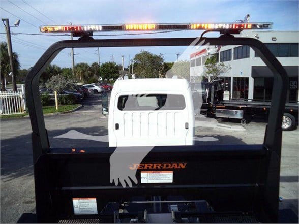 Back of Freightliner M2 106 Plus bed with Jerr-Dan branding, viewed from rear with light bar on top and white cab in background.