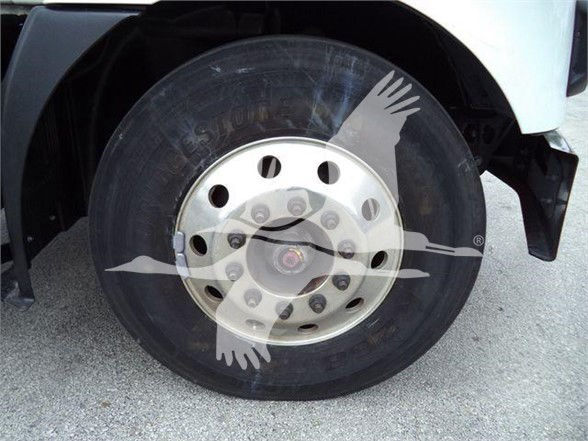 Wheel of a Mack MD7 truck with alloy hub and tire, faint text on tire and wheel.