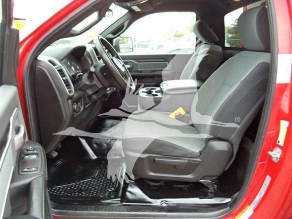 Ram 4500 interior with front seats, steering wheel, center console; gray cloth seats; open driver door; black floor mats; yellow item on passenger seat; red exterior