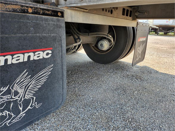 Part of a 2020 Manac COMBO trailer shows a wheel, mudflap with Manac logo and graphic, and undercarriage components.