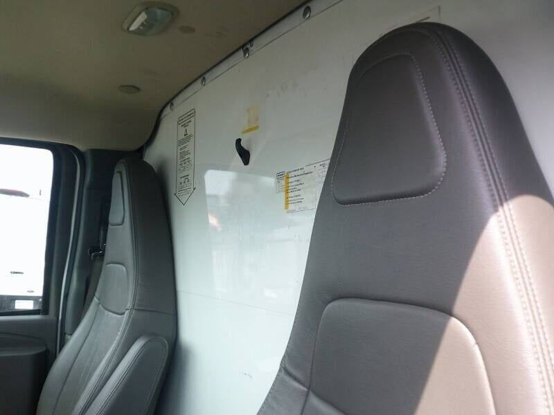 GMC Savana 3500 interior showing partition wall with warning labels between driver and cargo area.