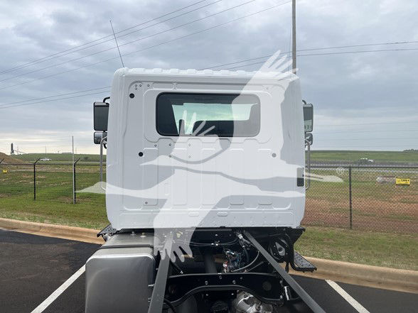 Cab and chassis truck rear view showing Hino L6 cab with window, door and chassis frame. No visible labels or numbers on the cab side.