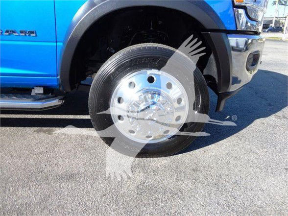 Ram 5500 front wheel area with blue truck, chrome hubcap, partial RAM badge on fender.