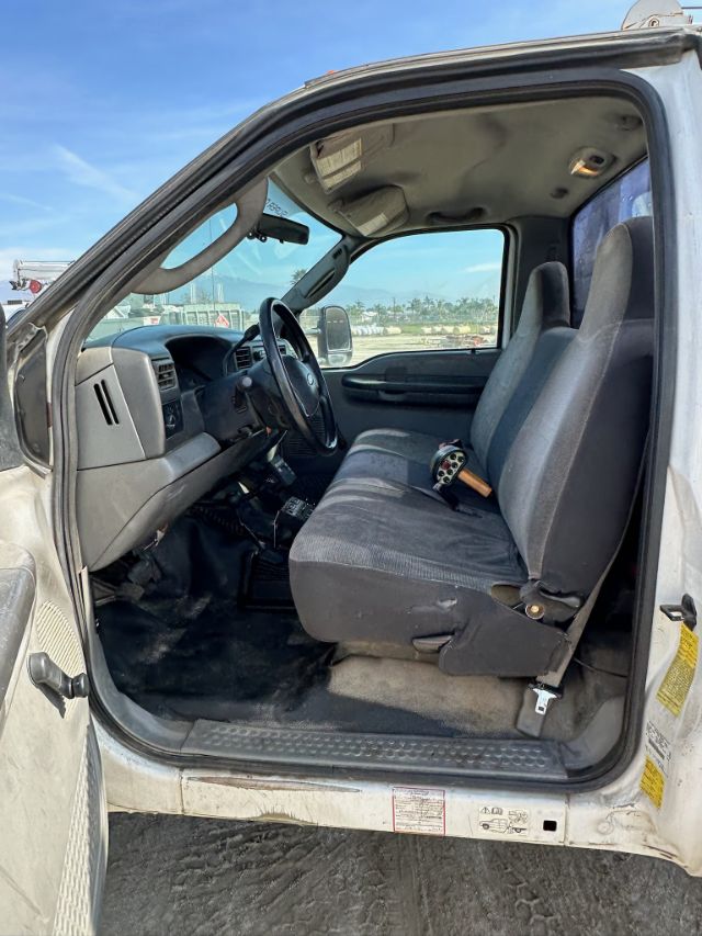 Ford F-550 truck cab interior showing front bench seat, steering wheel, dashboard, and driver's door area.