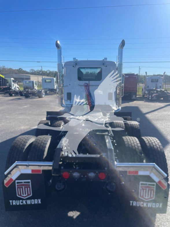 Kenworth T880 rear view with sleeper cab, dual rear axles, chrome exhaust stacks, fifth wheel and TruckWorx mud flaps visible.