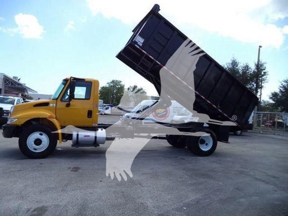 2019 International DURASTAR 4300 dump truck with yellow cab and black dump bed raised for dumping.