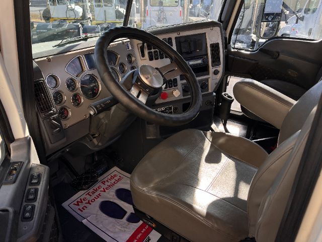 Cab interior of a 2013 Mack CHU613 Pinnacle truck showing steering wheel, dashboard with gauges, and tan seats.
