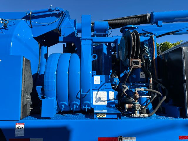 A blue Sterling L7500 truck chassis with a large circular hose reel and hydraulic components visible in the engine bay area.