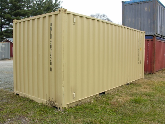 Yellow shipping container in an outdoor lot with other stacked containers in the background.