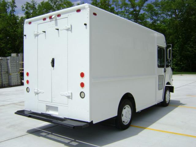 Rear and side view of a white Freightliner MT45 step van with back double doors and standard cargo door handles.