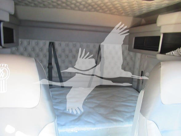 Kenworth W900L interior sleeper cab area with bunk bed visible under overhead storage.