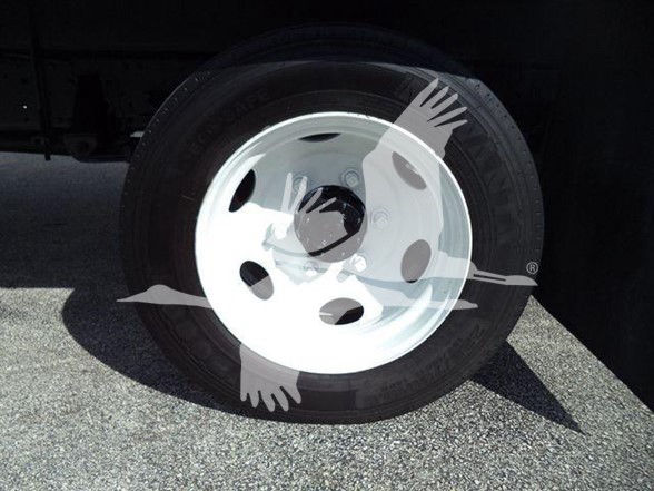 Isuzu truck wheel with white steel rim and tire, partial undercarriage visible.