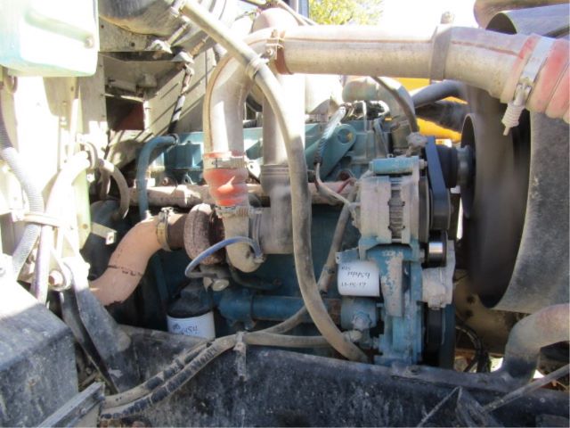 Vehicle engine bay with blue secondary engine components, hoses, and belts visible in a Mack CV513 truck bay.
