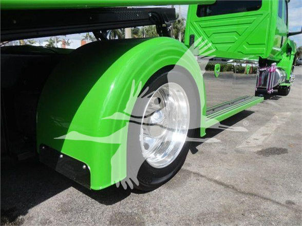 Green International MV truck wheel and fender close-up, chrome rim, bright lime body, step-side with black mudguard and wheel well.
