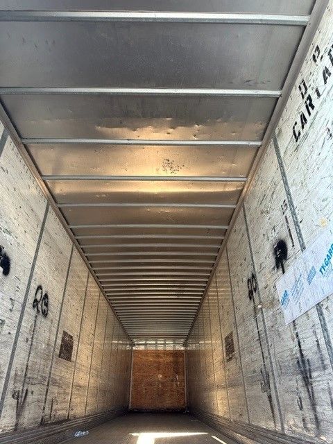 Inside of trailer with metal ceiling ribs and white insulated walls showing storage trailer interior.