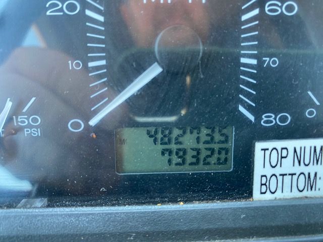 Instrument cluster showing gauge with 0-80 MPH, 0-150 PSI, and digital display reading 4827? 7932? (unclear) with a reflection.
