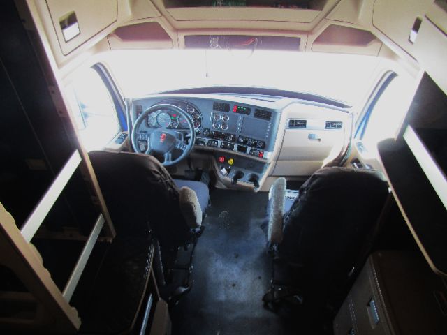 Kenworth T680 cab interior dashboard and driver seats from front view.
