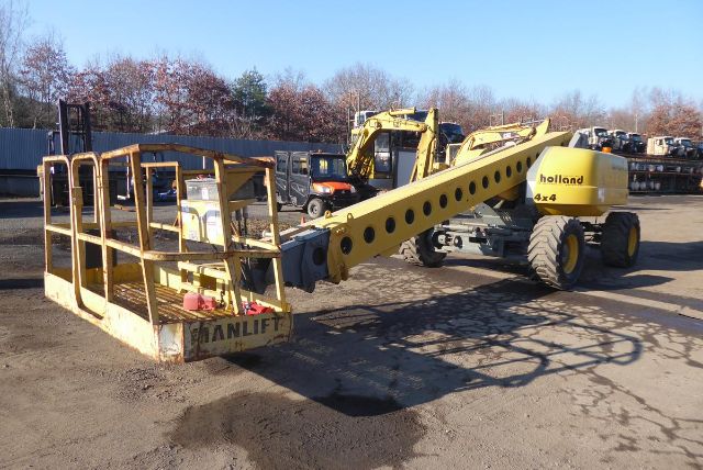 Grove T60 boom truck lifting arm visible with yellow chassis and work platform in an outdoor lot.