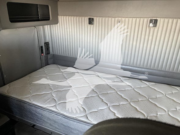 Kenworth T800 sleeper cab interior with a mattress and storage compartments.