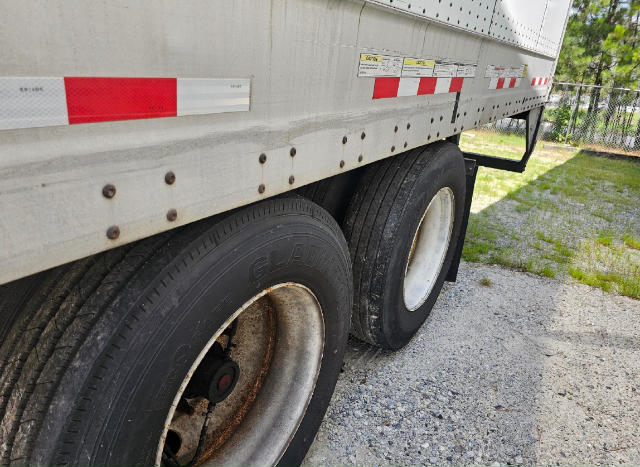 Truck trailer wheels and side of Vanguard VXP trailer with riveted steel body and dual tires.