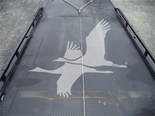 Flatbed trailer deck with a large white bird graphic in flight. No legible text visible besides the graphic.