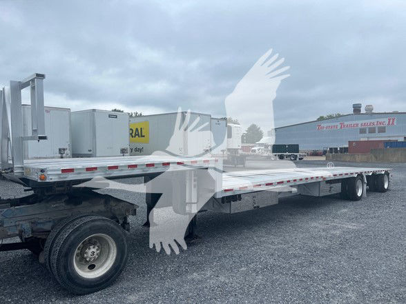 2018 Reitnouer Dropmiser trailer with expandable drop deck, visible side rails, dual rear axles, and front area showing utility components. Some small printed labels are present on equipment but not legible.