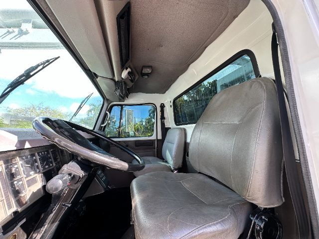 Interior of a 2000 International F-2554 vacuum truck showing steering wheel, dashboard, and seats.
