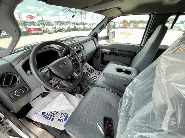 Interior view of a 2025 Ford F650 cab showing steering wheel, dashboard, center console, driver and passenger seats with plastic protectsors.