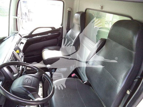Truck cab interior showing driver's seat, passenger seat, steering wheel, front dashboard.