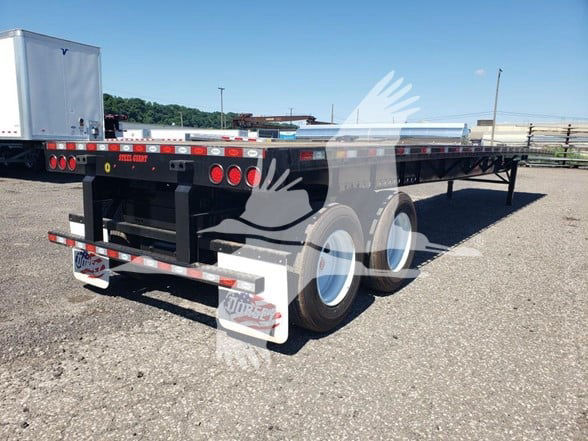 Flatbed trailer showing dual rear wheels and black metal frame with white wheels and lime green accents; New Dorsey Steel logo on side; VIN and stock numbers visible.