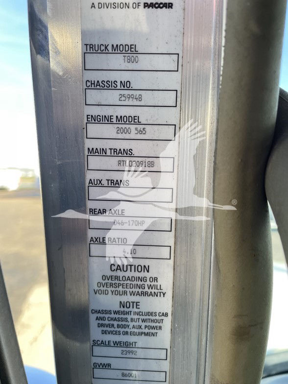 Truck door jamb label showing truck model T800, chassis number 259946, engine model 2000 565, main trans RTL?20918B, axles, rear axle 046-170HP, axle ratio 4.10, caution note about overload, GVWR 86001