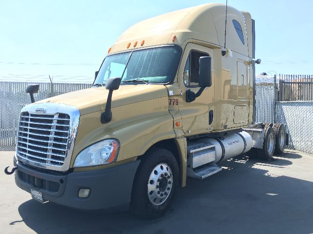 Freightliner Cascadia 125 sleeper cab tractor in tan color with chrome grille and side fuel tanks.