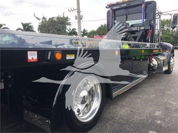 Peterbilt 337 tow truck flatbed with black exterior, chrome wheels, and purple-accented cab edges.