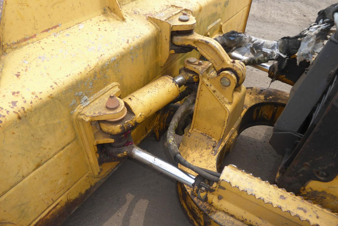 John Deere 650HLT heavy equipment linkage showing hydraulic cylinder and pin joints.
