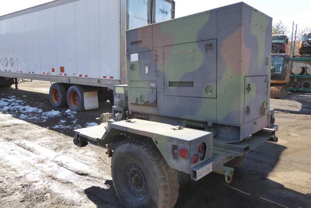 Mep-804a trucking equipment generator on a trailer with camouflage paint, mounted behind a wheel, with a boxy enclosure and trailer hitch.