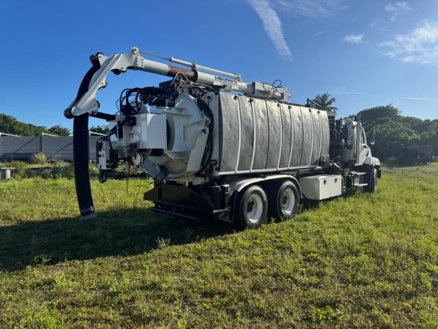 2014 Freightliner 114SD vacuum truck with large stainless tank and rear-mounted vacuum hose arm.
