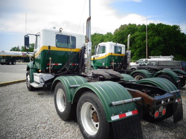 Freightliner Columbia tractor truck chassis showing rear view with green and white cab and dual rear axles.