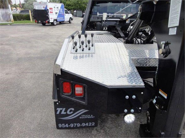Ram 4500 tow truck rear deck with control levers on diamond plate surface and TLC Truck & Equipment logo on mudflap.