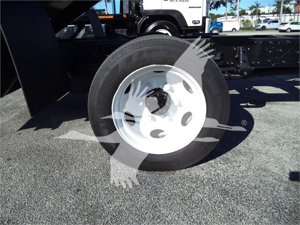 Isuzu truck dump chassis wheel showing front tire and white rim with overlay watermark.