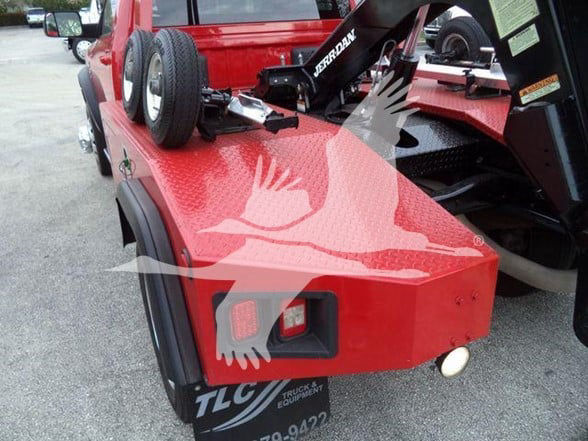 Red tow truck equipment on a Ram 4500 setup showing TLC license plate and mounted hydraulic components.